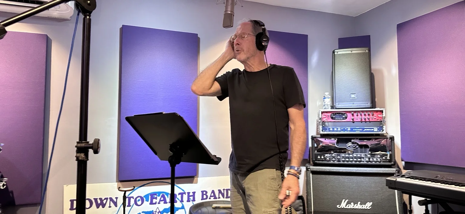 A vocalist wearing headphones in the recording room